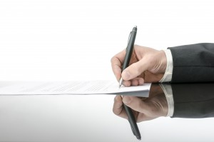 Signing a contract on a black table. With copy space and reflection.